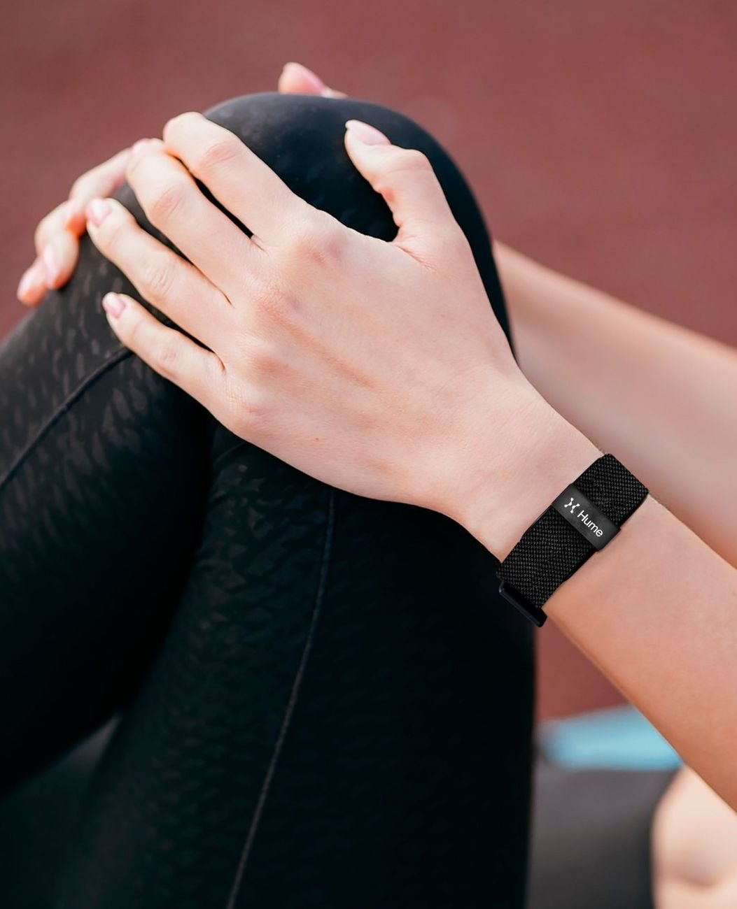 Close-up of hands with Hume Band visible on wrist during a stretching recovery routine